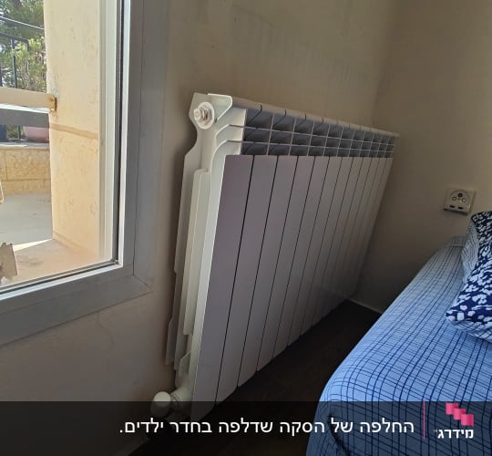 רדיאטור חימום ליד חלון בחדר שינה